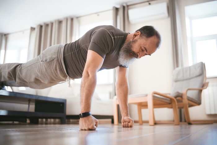 Bearded man exercising indoors with funny confessions mood