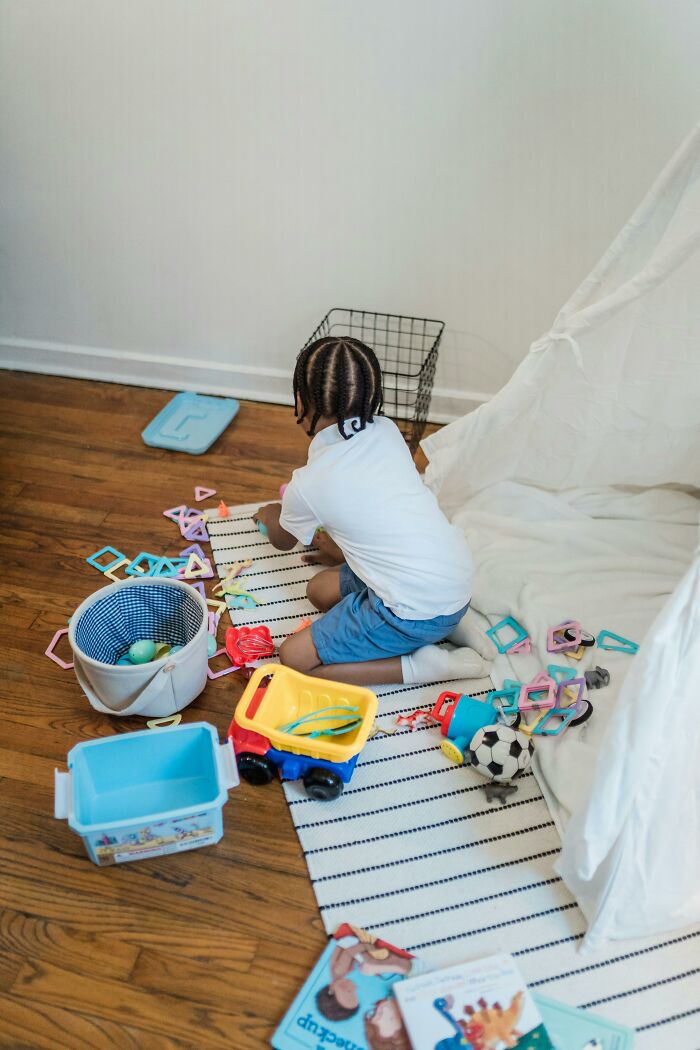 Child playing with toys and building blocks on floor play area
