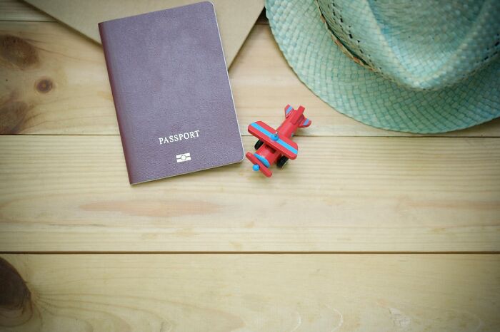 Passport and toy airplane on wooden table