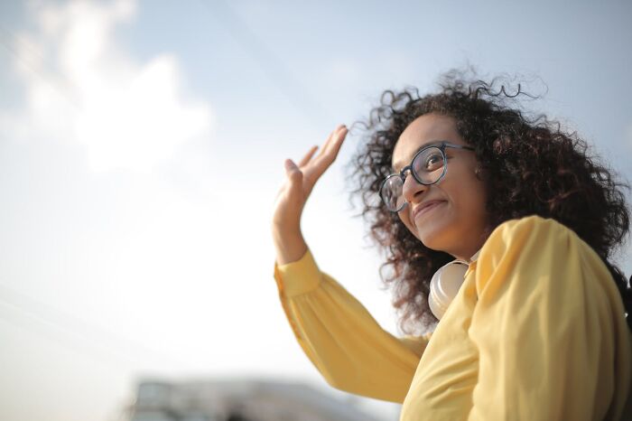 Woman waving happily outdoors with courtroom stories theme