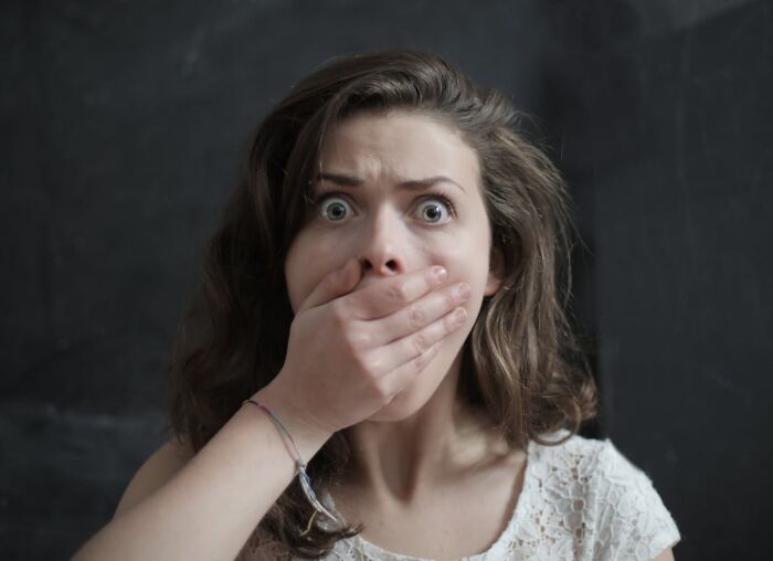 Shocked woman covering mouth showing laziness saving from disaster