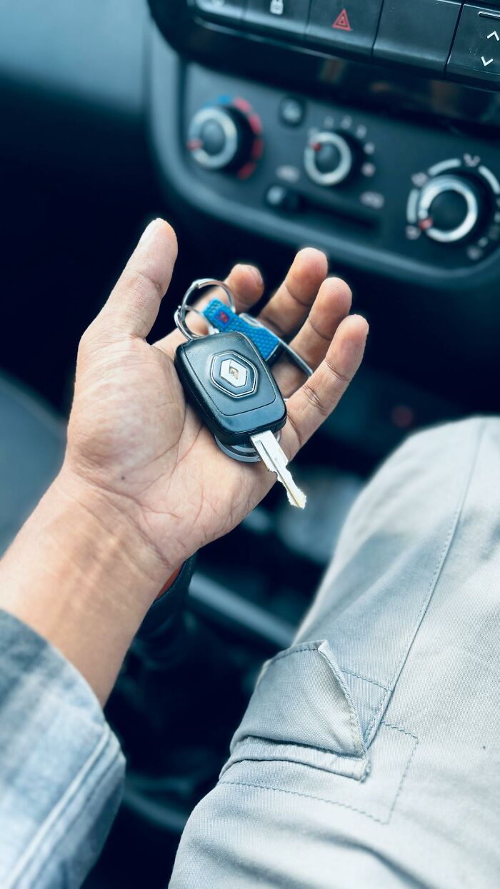 A person's hand holds car keys, possibly questioning reality or experiencing a glitch in the matrix.