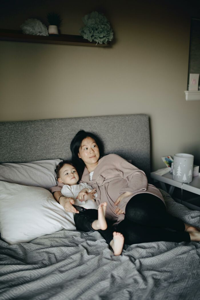 Mother and toddler relaxing together on a bed