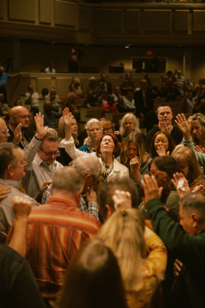 Large group in prayerful worship showing a cult escape spiritual moment