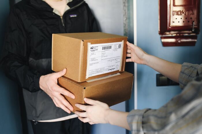 A delivery person hands two brown boxes to a customer. This daily routine might make you question reality; are there glitches in the Matrix?