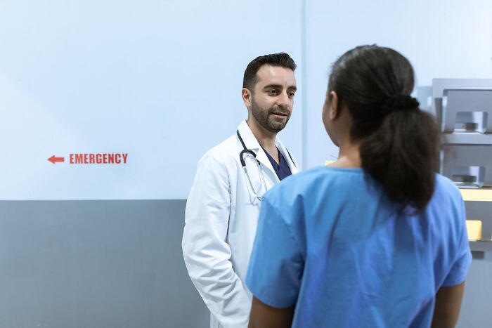 Doctor and nurse talking near emergency department in hospital setting