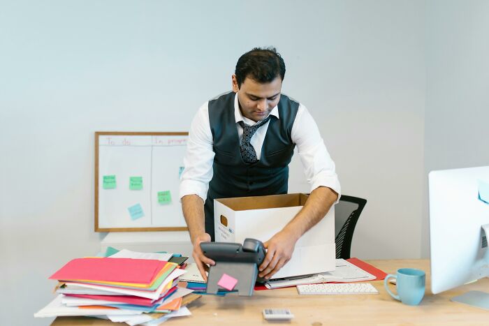Man packing belongings in box at office quitting job