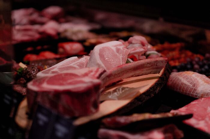 Raw cuts of meat in display with dim lighting