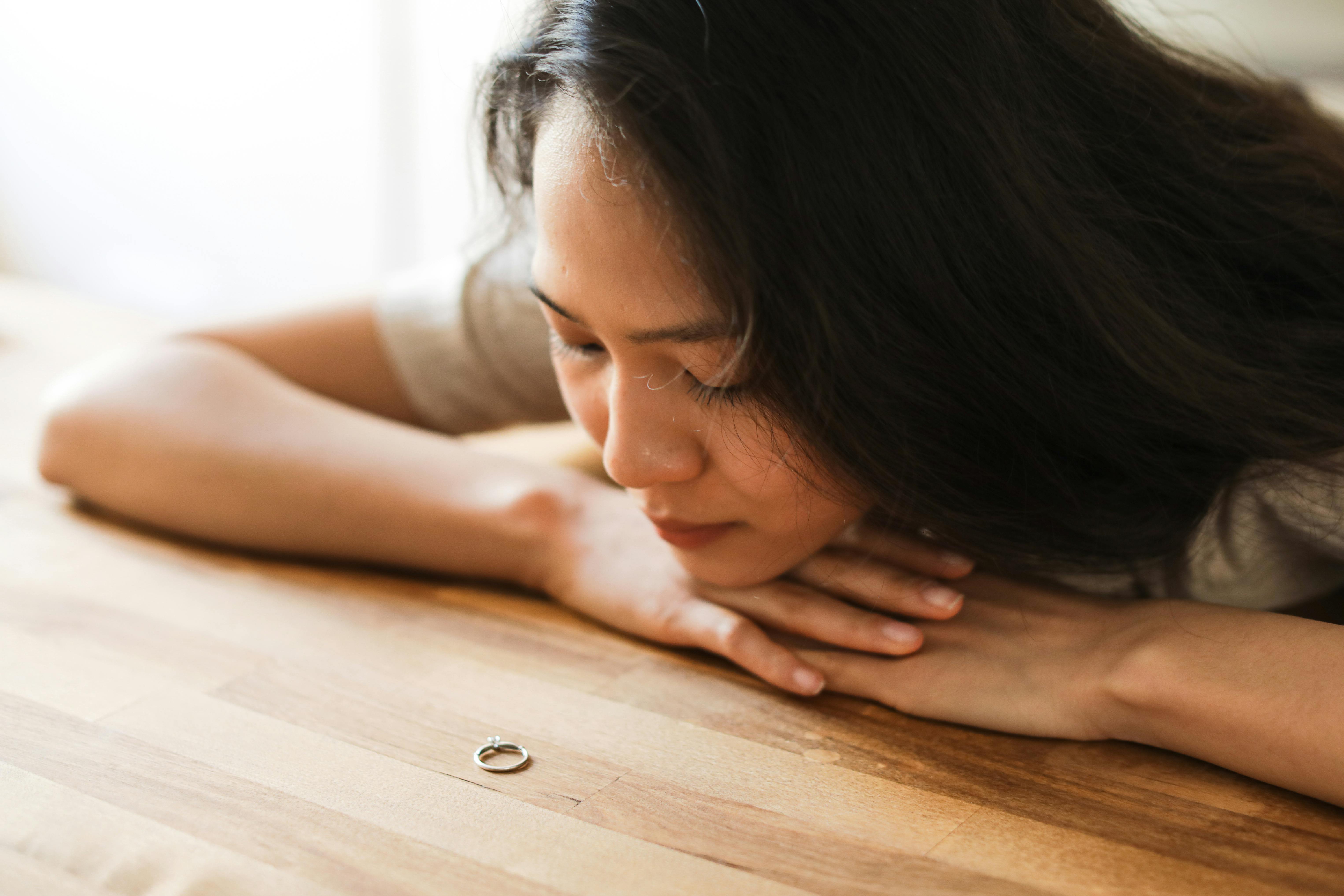 Woman makes a satisfying decision with fianc&eacute; and 2 kids, looking at engagement ring on table