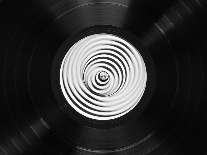 Close-up of vinyl record with a swirling white and black pattern on the label, representing literal interpretations of lyrics Close-up of vinyl record with a swirling white and black pattern on the label, representing literal interpretations of lyrics