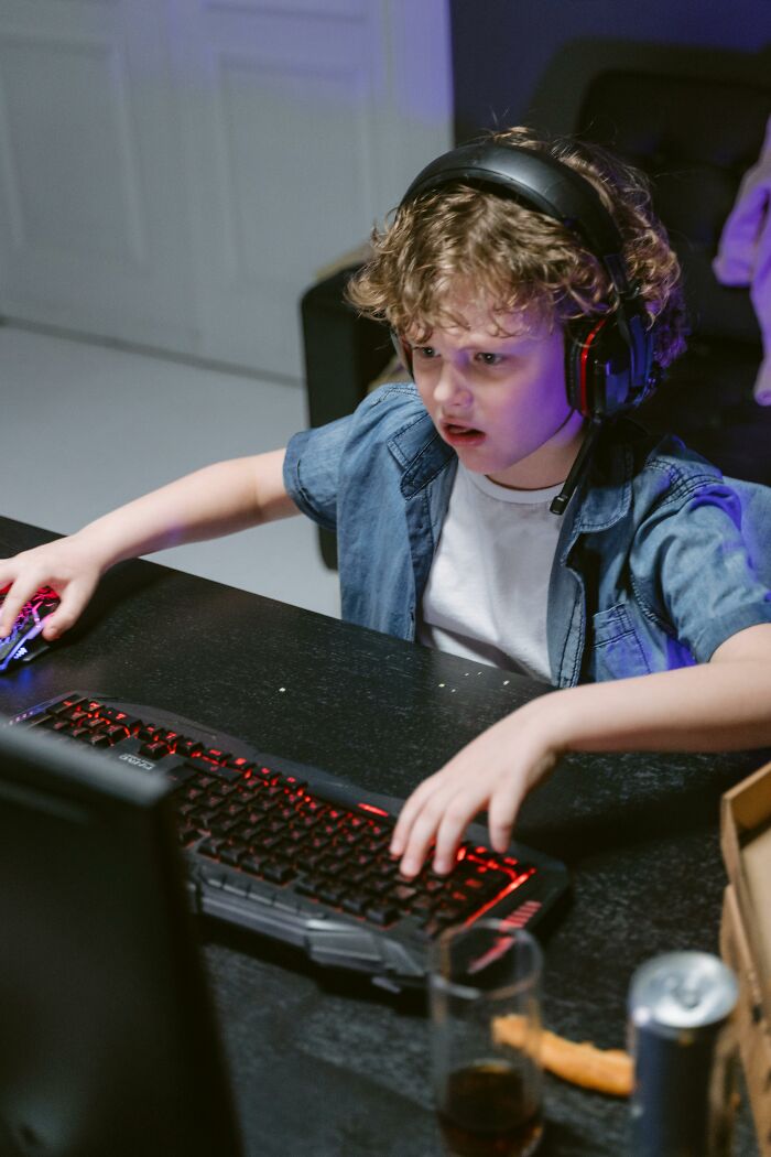 Child gaming intensely with headset and laughing confessions