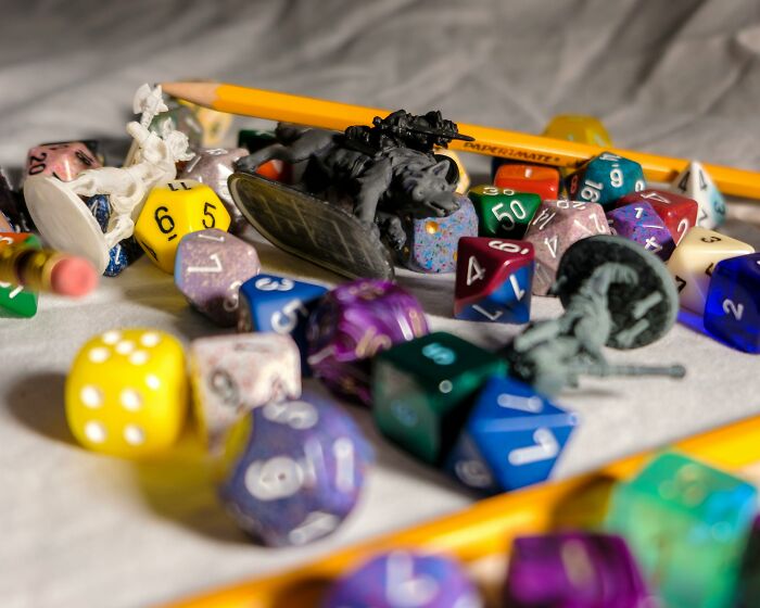 Assorted colorful dice and miniatures for board games on a table