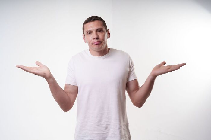 Man shrugging with white shirt expressing laziness saving from disaster