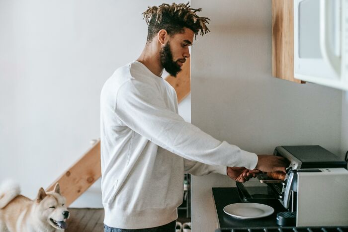 Young man cooking in kitchen with dog nearby weird confessions