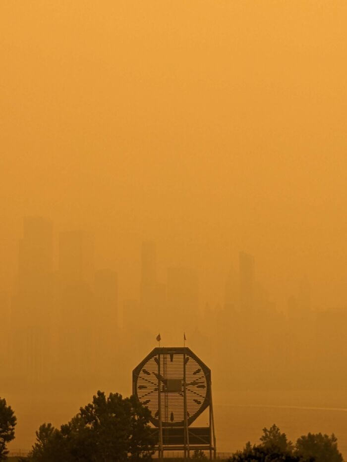 City skyline hidden in sandstorm with large clock structure foreground
