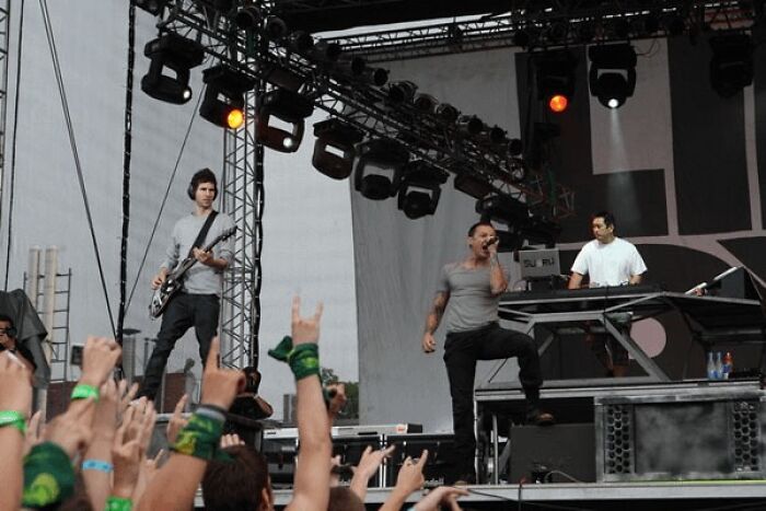 Live band performing on stage with enthusiastic audience at music concert