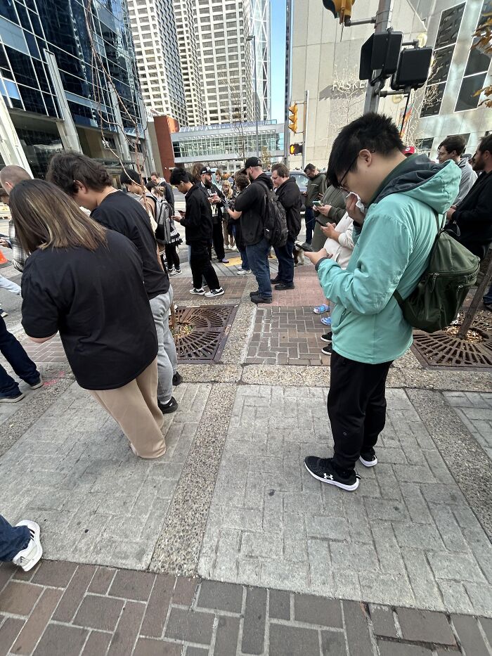 Crowd standing on city street in rare moment of waiting