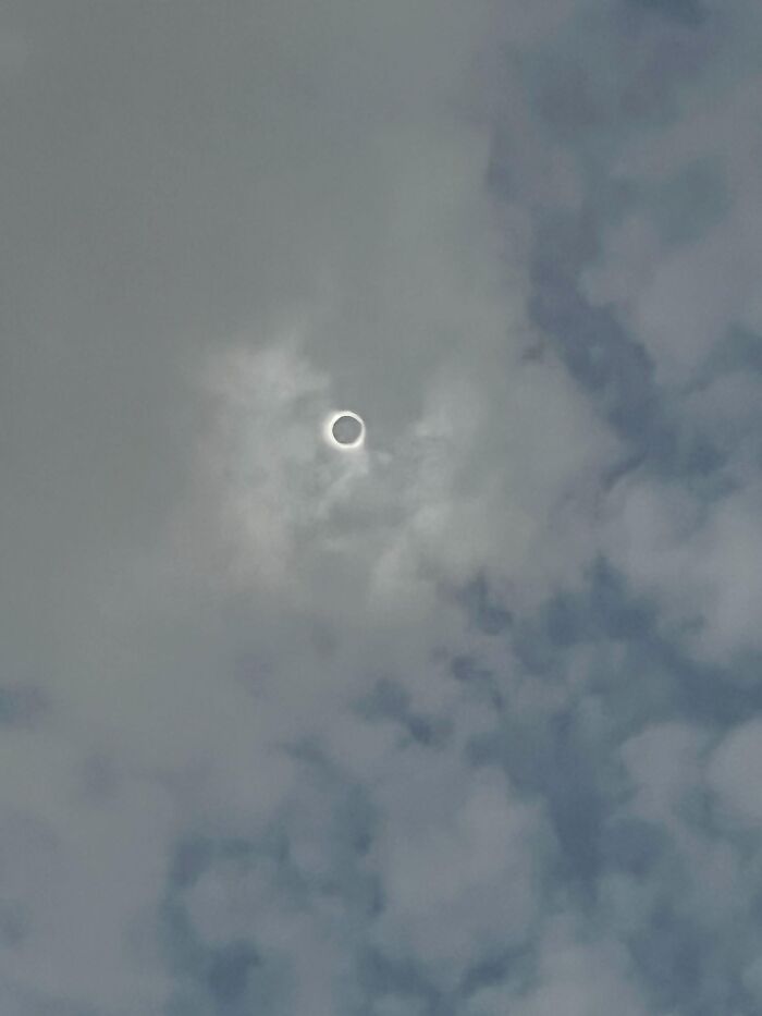 Rare solar eclipse shining brightly through cloudy sky