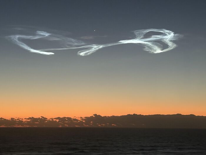 Rare moment of unusual cloud formation against sunset sky over ocean