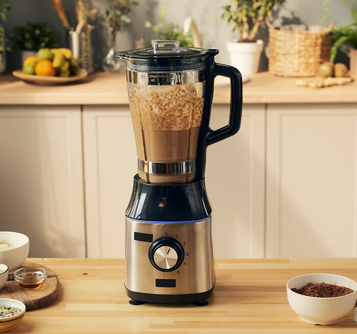 A blender making a smoothie, saving money by creating homemade habits instead of buying expensive drinks.