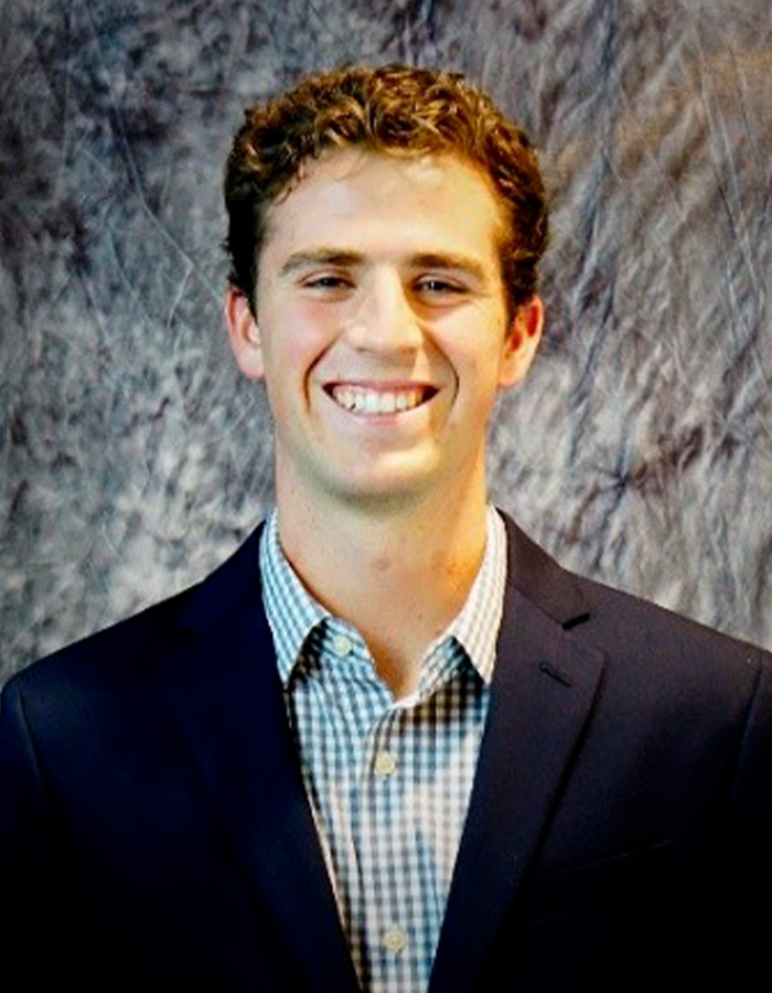 Portrait of former Princeton student smiling against textured background Portrait of former Princeton student smiling against textured background