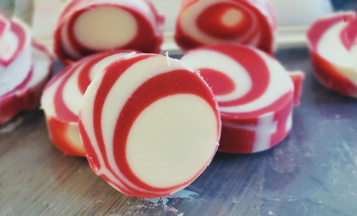 Red and white swirl patterned round candles on table