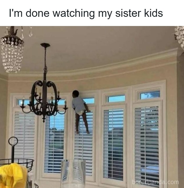 Child humorously stuck on window blinds in a home, caption about babysitting sister's kids