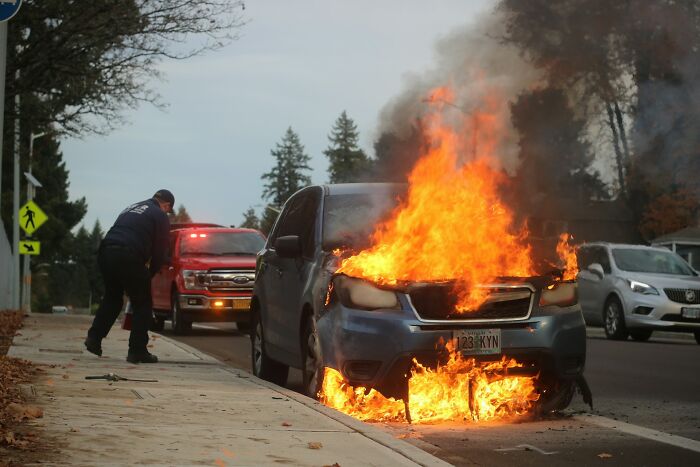Car engulfed in flames on street with emergency responder in boneheaded comments