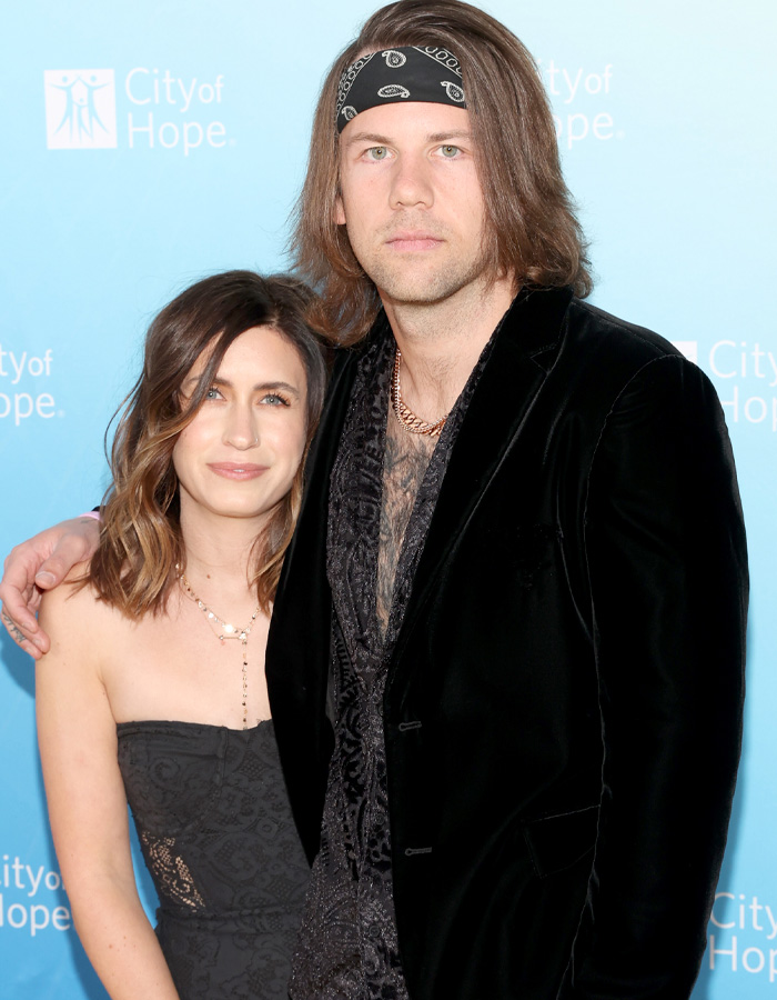 Rockstar and wife posing at City of Hope event with supportive embrace Rockstar and wife posing at City of Hope event with supportive embrace