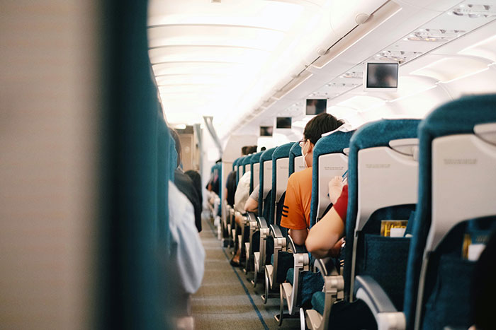 Interior view of passengers sitting inside an airplane cabin during flight