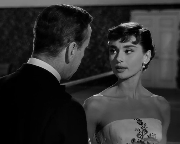 Audrey Hepburn as a "catfish" in a strapless dress. Her makeup enhances her classic beauty, adding to the transformation.