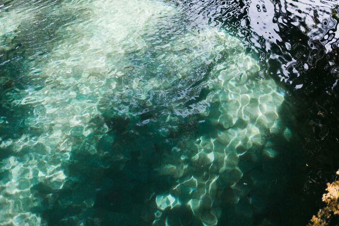 Clear water revealing rocky underwater cave floor