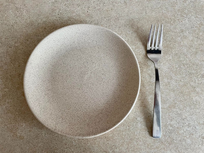 Empty plate and fork symbolizing fasting Empty plate and fork symbolizing fasting