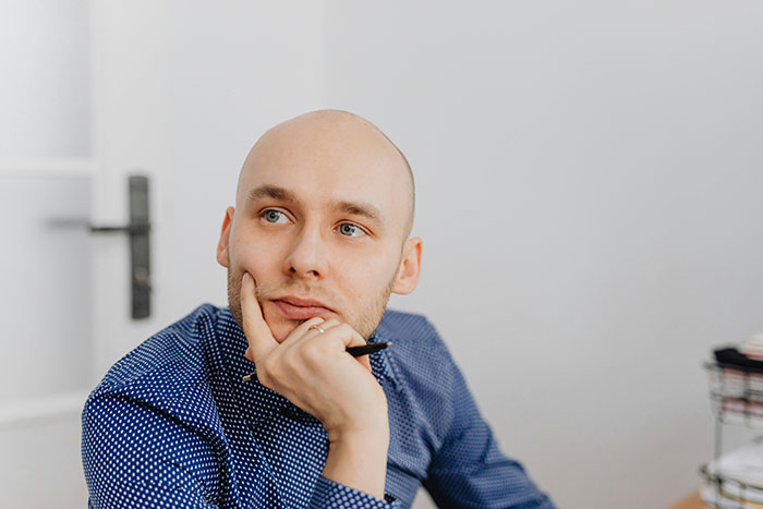Thoughtful bald man indoors scientific facts