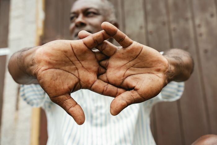 A man stretching his hands, palms facing each other, fingers interlocked. His hands are in sharp focus, illustrating outdated facts.