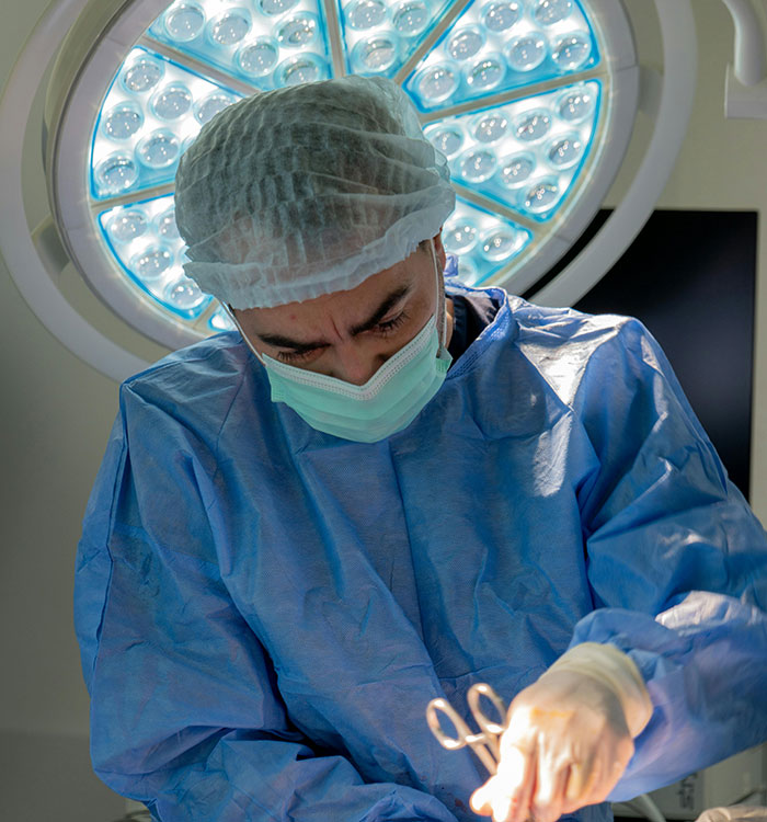 Surgeon performing cosmetic surgery under bright light showing beauty lies