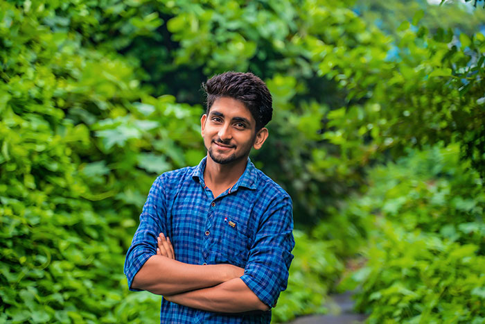 Smiling man in blue checkered shirt in green outdoor setting beauty lies uncovered