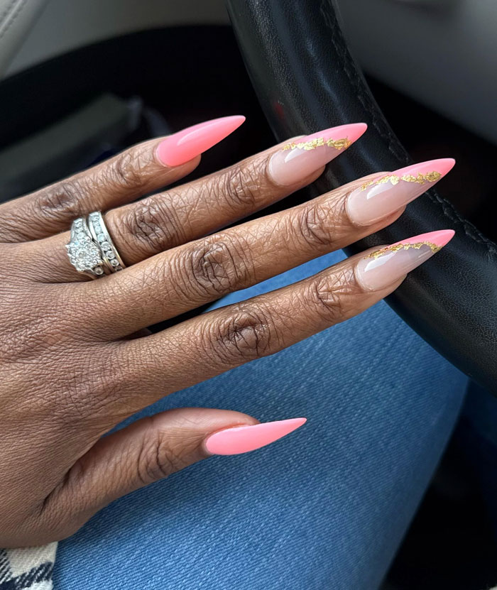 Close up of manicured stiletto nails pink and gold accents beauty lies uncovered