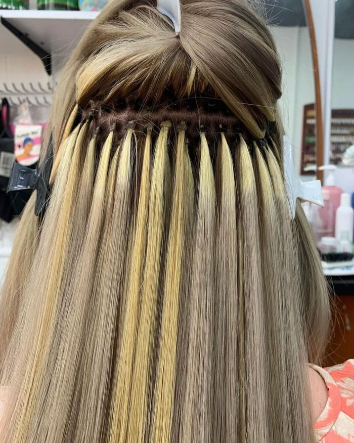 Back of head showing installed blonde hair extensions beauty styling
