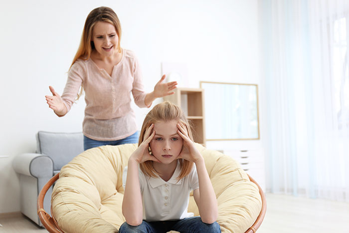 Mother scolding daughter in living room over cleaning issues Mother scolding daughter in living room over cleaning issues