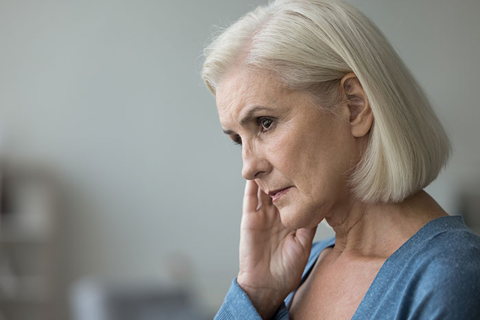 Thoughtful senior woman reflecting on cleaning criticism and family conflict Thoughtful senior woman reflecting on cleaning criticism and family conflict