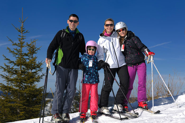 Family dressed in ski gear during winter vacation Family dressed in ski gear during winter vacation