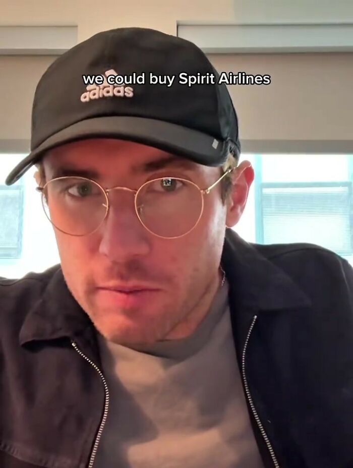 A man in an Adidas hat and round glasses looks at the camera, with text "we could buy Spirit Airlines."