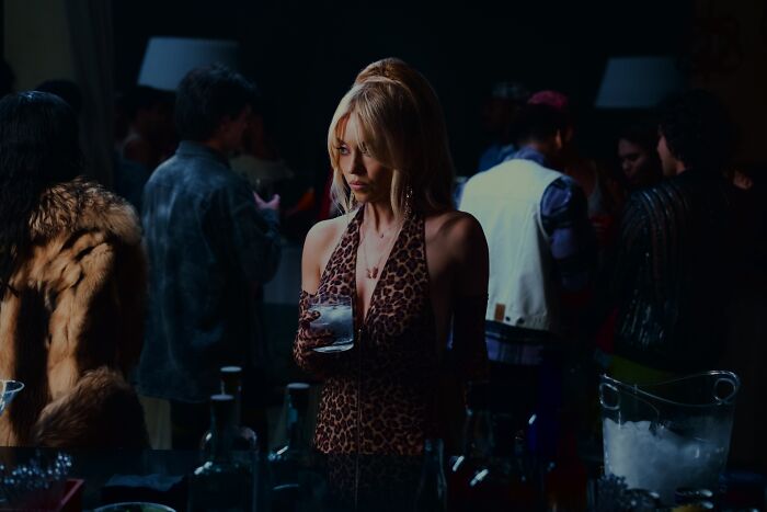 Sydney Sweeney com um top com estampa de leopardo, segurando uma bebida em uma festa, deixa os fãs de Euphoria arrasados.