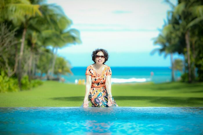 Woman relaxing by a pool with tropical landscape, representing evil MILs stories