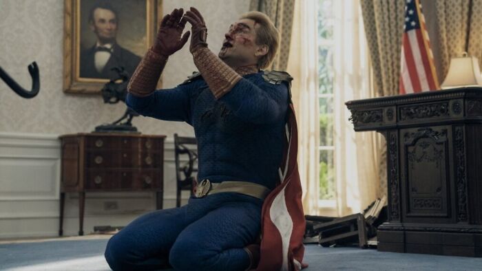Homelander, bloodied and on his knees in an office, in The Boys Finale, exploring character's fate.