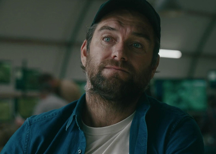 Close-up of The Boys star in casual cap and shirt in a dim setting Close-up of The Boys star in casual cap and shirt in a dim setting