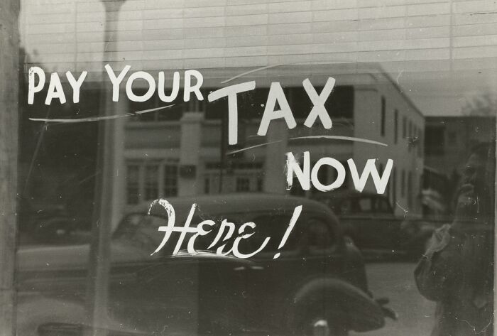 Sign urging people to pay their taxes now reflecting tax economy