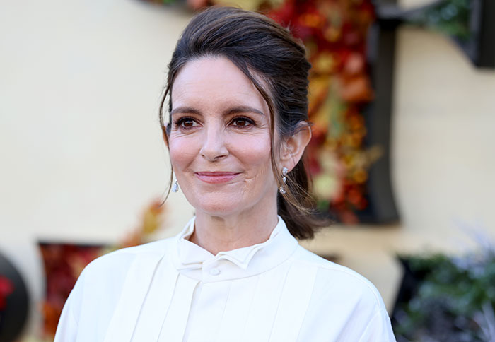 Tina Fey smiling at an autumn event addressing manspreading controversy