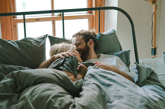 Couple embracing in bed enjoying a loving moment on January 6